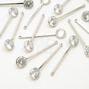 May include: A collection of silver-toned hair pins with clear rhinestone accents. The pins are arranged on a white surface.