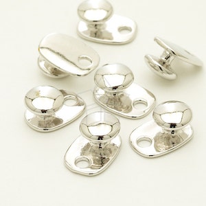 Puede incluir: Cierre de metal plateado con un pomo redondo y una base rectangular con un agujero. Los cierres están diseñados para sujetar correas u otros materiales.