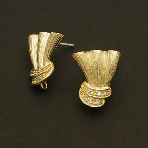 May include: A pair of gold-tone earrings with a fan-shaped design and clear crystal accents.