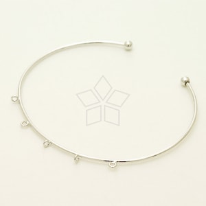 May include: Silver bangle bracelet with five small jump rings hanging from the bottom. The bracelet has a ball at each end.