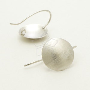May include: A pair of silver hoop earrings with a brushed finish. The earrings are simple and elegant.