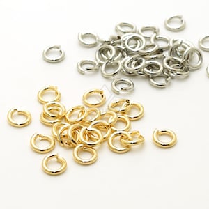 May include: A pile of gold jump rings and a pile of silver jump rings. The jump rings are small, circular metal rings used for connecting jewelry components.