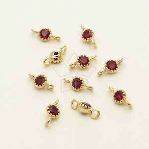 Op de afbeelding: Tien gouden springringen met rode edelsteen accenten. Elke ring heeft twee lussen om sieradencomponenten aan te bevestigen.