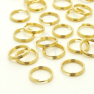 Puede incluir: Un conjunto de anillos de salto de metal dorado, ideales para la elaboración de joyas o proyectos de artesanía.