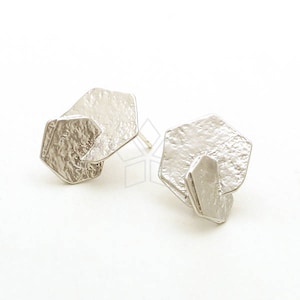 Könnte beinhalten: Ein Paar silberne Ohrringe mit geometrischem, strukturiertem Design. Jeder Ohrring besteht aus zwei sich überlappenden sechseckigen Formen.