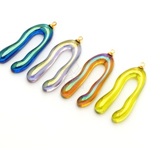 Può includere: Quattro ciondoli in vetro iridescente blu, viola, arancio e giallo. Ogni ciondolo ha un anello dorato in cima per essere attaccato a gioielli.