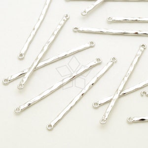 Pode incluir: Um grupo de barras de conexão de metal prateado com laços em cada extremidade. As barras são texturizadas e têm um acabamento martelado.