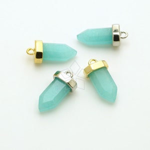 May include: Four turquoise blue gemstone pendants with gold and silver accents. Each pendant has a pointed tip and a loop for attaching to a chain or cord.