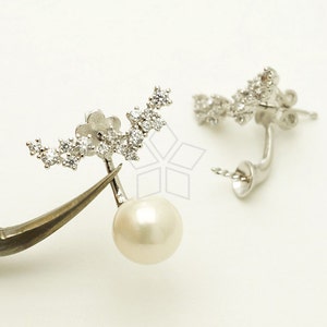 May include: A pair of silver earrings with a pearl drop and a delicate design of sparkling cubic zirconia stones.