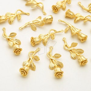 May include: A collection of gold-tone metal rose charms with a delicate design. Each charm features a single rose with leaves and a loop for attaching to jewellery or other crafts.