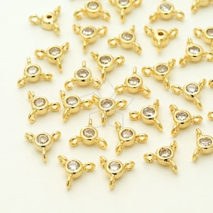 May include: A group of gold-tone metal connector pieces with clear rhinestones. Each piece has three loops for attaching jewelry.