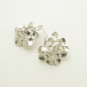 Könnte beinhalten: Ein Paar silberne Ohrringe in Form von Hortensienblüten. Die Ohrringe sind aus strukturiertem Metall gefertigt und haben ein zartes, florales Design.