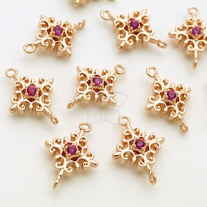 Pode incluir: Um conjunto de oito pingentes de metal dourado com um design quadrado e uma pedra de strass rosa no centro. Cada pingente tem dois laços para prender a joias ou outros artesanatos.