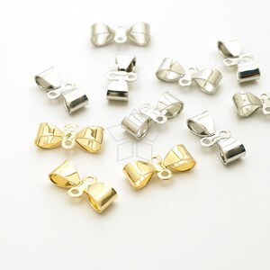 May include: A collection of gold and silver bow-shaped metal clasps for jewelry making. The clasps are designed to be used for necklaces, bracelets, and other jewelry projects.