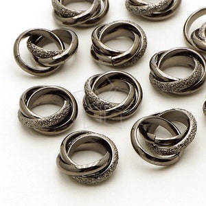May include: A group of black metal rings with a textured finish. The rings are interlocked and have a circular shape.
