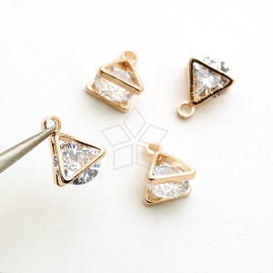 May include: Three gold-tone triangle-shaped charms with clear rhinestones. Each charm has a loop at the top for attaching to jewelry.