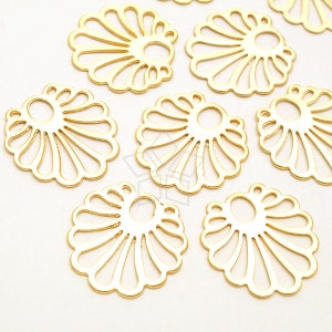 May include: A set of eight gold-colored metal decorative charms in the shape of a stylized flower with a hole in the center. The charms are all the same size and shape.