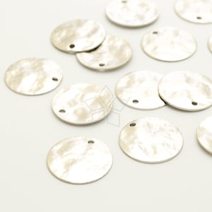 May include: A group of silver-toned round metal charms with a hammered texture and a hole for hanging.