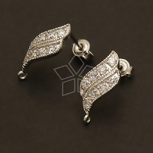 May include: A pair of silver earring findings with a leaf design and clear cubic zirconia stones. The findings have a loop at the bottom for attaching a dangle charm.