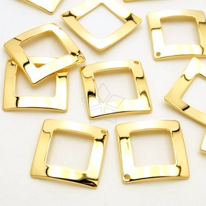 以下が含まれることがあります： 光沢のある金色の正方形のジュエリーパーツのコレクション。各パーツは、角が丸く、小さな穴が開いた正方形のフレームを持っています。パーツは明るい背景に配置されています。