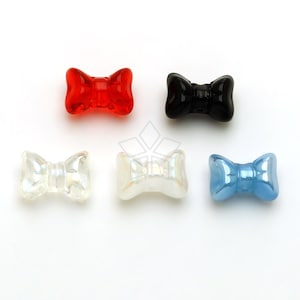 May include: Six plastic bow-shaped beads in different colours: red, black, white, and blue.