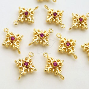 May include: Gold-tone metal charms with a filigree design and a single pink rhinestone in the centre. Each charm has two jump rings for attaching to jewellery.