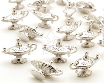 May include: A collection of silver genie lamps with the word "wish" engraved on them. The lamps are arranged in a scattered pattern on a white surface.