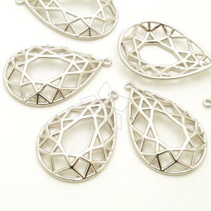 Puede incluir: Cinco colgantes de metal plateado en forma de lágrima con un diseño geométrico. Los colgantes tienen un agujero en la parte superior para sujetarlos a joyas.