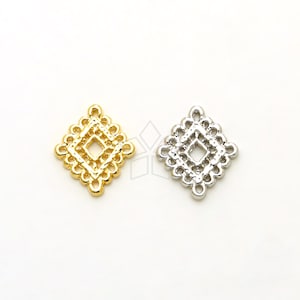 Puede incluir: Dos dijes decorativos de metal en forma de diamante, uno dorado y otro plateado, con intrincados diseños calados. Cada dije tiene cuatro bucles para sujetar a joyas u otras manualidades.
