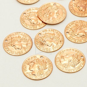 May include: A set of ten gold-toned metal charms shaped like coins with the words "REPUBLIQUE FRANCAISE" and a profile of a woman's face.