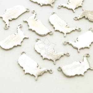 May include: A group of silver-colored metal charms shaped like the outline of the United States. Each charm has two jump rings for attaching to jewelry or other crafts.
