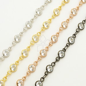 Puede incluir: Tres hebras de cadena con cristales redondos transparentes. Las cadenas son plateadas, doradas y negras.