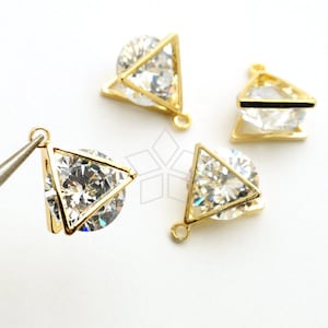 May include: Four gold-tone triangle-shaped pendants with clear crystal stones. Each pendant has a loop at the top for attaching to a chain or other jewelry.