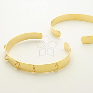 May include: Two gold metal bangles, one with four small loops, the other plain.