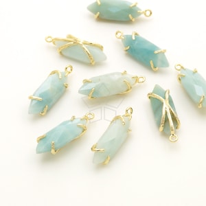 May include: Ten gold-toned pendants with a light blue gemstone in the center. Each pendant has a wire frame around the gemstone.