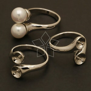 May include: Three silver rings with open settings for adding pearls or other gemstones. The rings are designed to hold two pearls or gemstones, one on each side of the ring band.