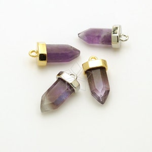 Puede incluir: Cuatro colgantes de punta de cristal de amatista con detalles dorados y plateados. Los colgantes son perfectos para la elaboración de joyas o manualidades.
