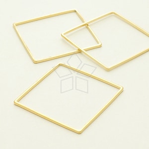 May include: Three gold-coloured metal hoops of different sizes, arranged in a triangular shape on a white background.