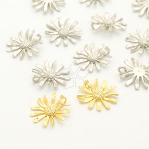May include: A collection of silver and gold daisy-shaped charms with a loop for attaching to jewelry or other crafts.