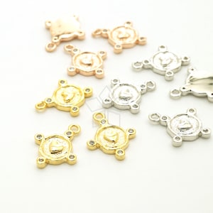 Puede incluir: Surtido de conectores de amuleto de corazón en oro, plata y oro rosa con acentos de cristal transparente. Cada amuleto presenta un diseño de corazón y cuatro bucles para sujetarlo a joyas.