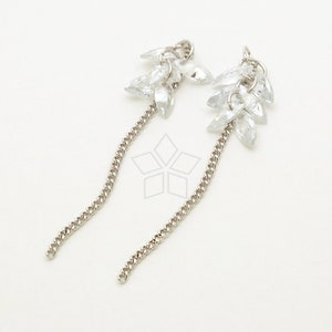 May include: A pair of silver dangle earrings with a chain and a cluster of clear crystal teardrop-shaped stones.