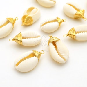 May include: A collection of white cowrie shells with gold wire wrapped around the top, ready to be used for jewelry making.
