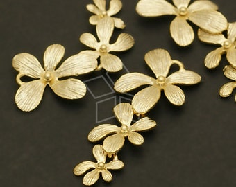 May include: A set of gold-toned metal flower charms. The charms are in the shape of a five-petal flower with a textured surface. The charms are perfect for adding a touch of elegance to jewelry, crafts, and other projects.