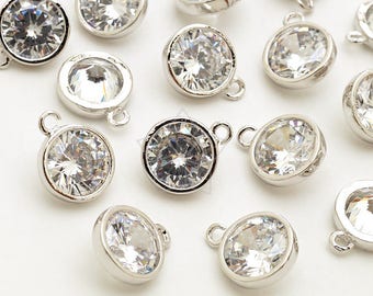 May include: A group of silver-toned metal charms with clear crystal rhinestones. Each charm has a loop at the top for attaching to a necklace, bracelet, or other jewelry.