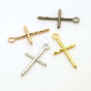 May include: Four hammered metal cross charms in different finishes: gold, silver, rose gold, and black. Each charm has a loop at the top for attaching to jewelry.