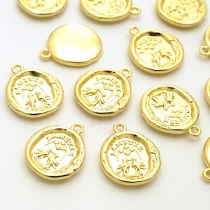 以下が含まれることがあります： 装飾的なフォントで「I AM YOURS」というテキストと、木と2羽の鳥のデザインが施された、金色の金属製チャームのコレクションです。チャームの上部にはループが付いており、ジュエリーやその他のクラフトに取り付けることができます。