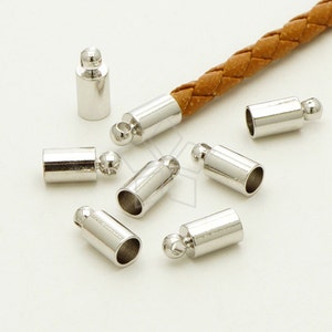 May include: Silver metal end caps for cord or leather bracelets. The end caps have a small ball on the end and a hole for threading cord.