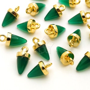 May include: A collection of green gemstone charms with gold-coloured metal detailing. Each charm has a conical shape and a small loop. The charms are scattered across a white surface, ideal for jewellery making.