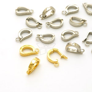 May include: An assortment of silver and gold-colored jewelry clasps. The clasps are in various designs, some with textured patterns. The clasps are arranged on a white surface, showcasing their details and finishes. These clasps are ideal for jewelry making.