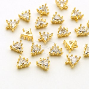 May include: A collection of gold-tone triangle charms with clear crystal accents. Each charm features a small loop for attaching to jewellery or other crafts.